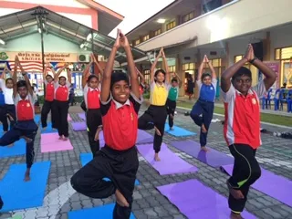 MYS volunteers teaching yoga to school children